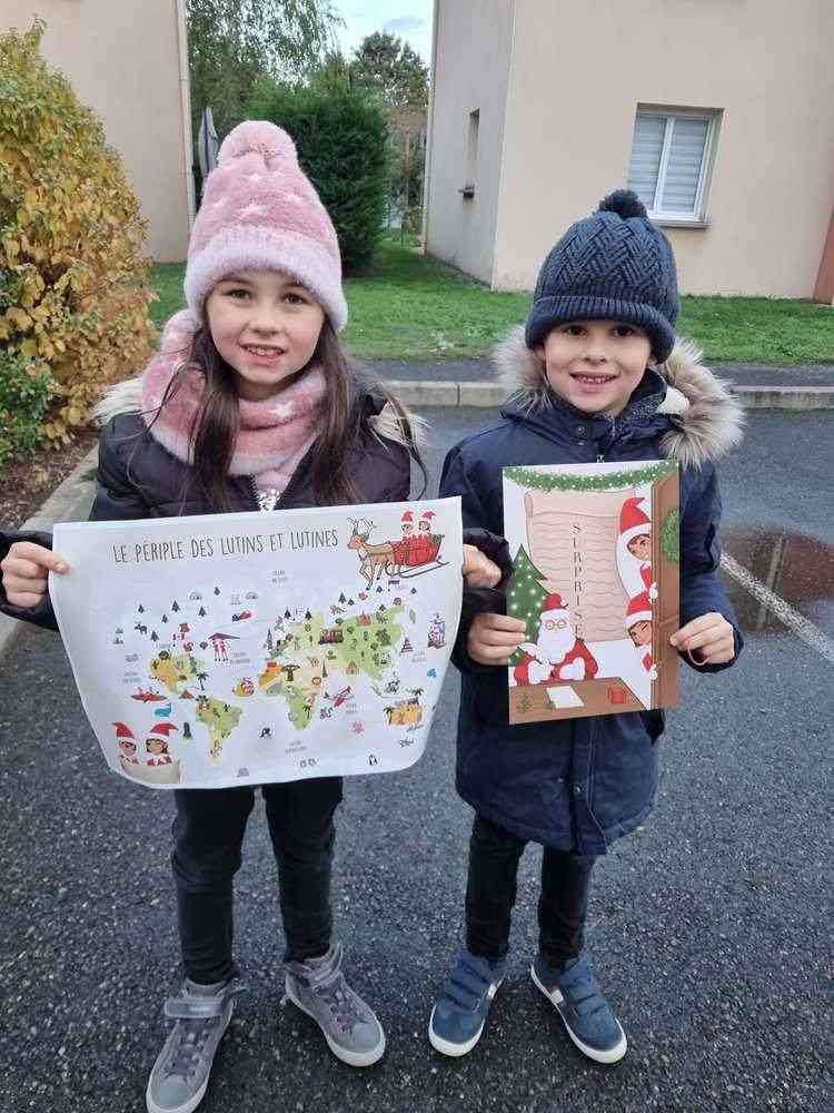 Deux enfants dehors montrant la carte Le périple des lutins et lutines et le livre Surprise