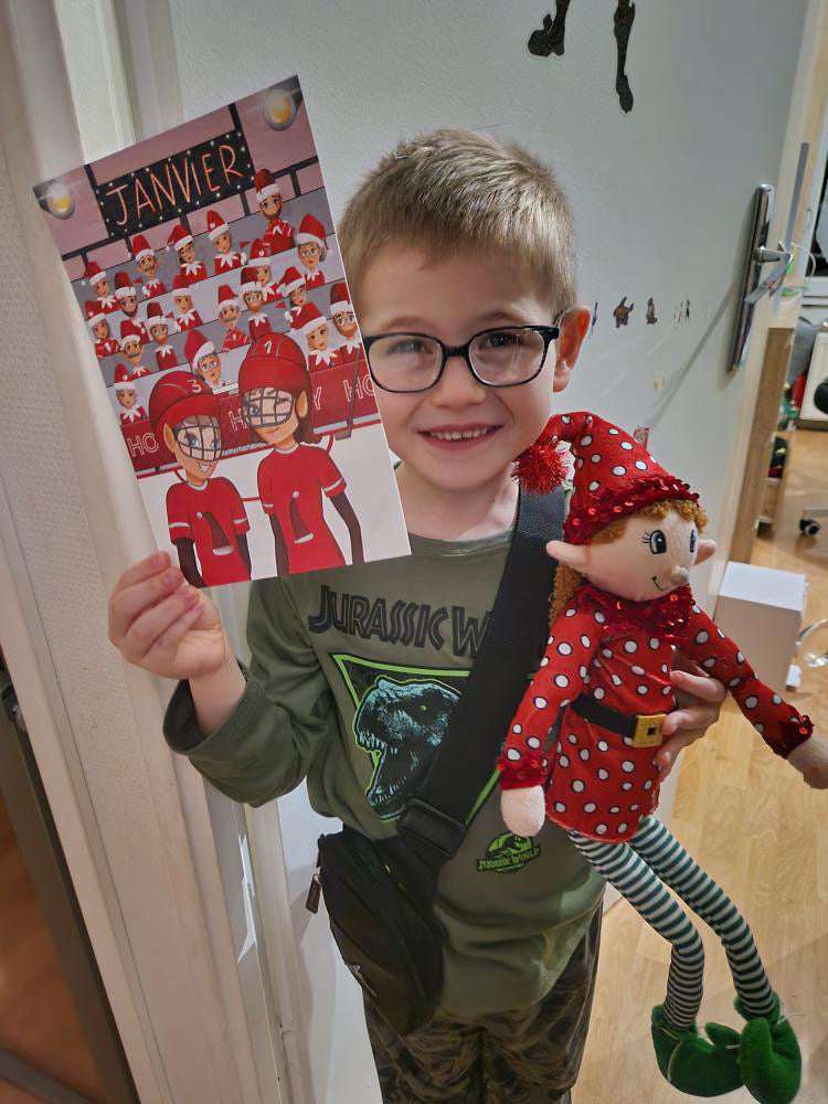 Enfant tenant un lutin en peluche à pois et l'affiche Janvier remplie de lutins supporters