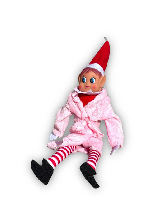 Lutin farceur assis en peignoir rose, bonnet rouge pointu et chaussettes rayées rouge et blanc