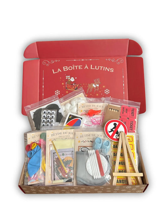 La box La Boîte à Lutins ouverte, remplie de sachets de bêtises numérotés et de leurs accessoires